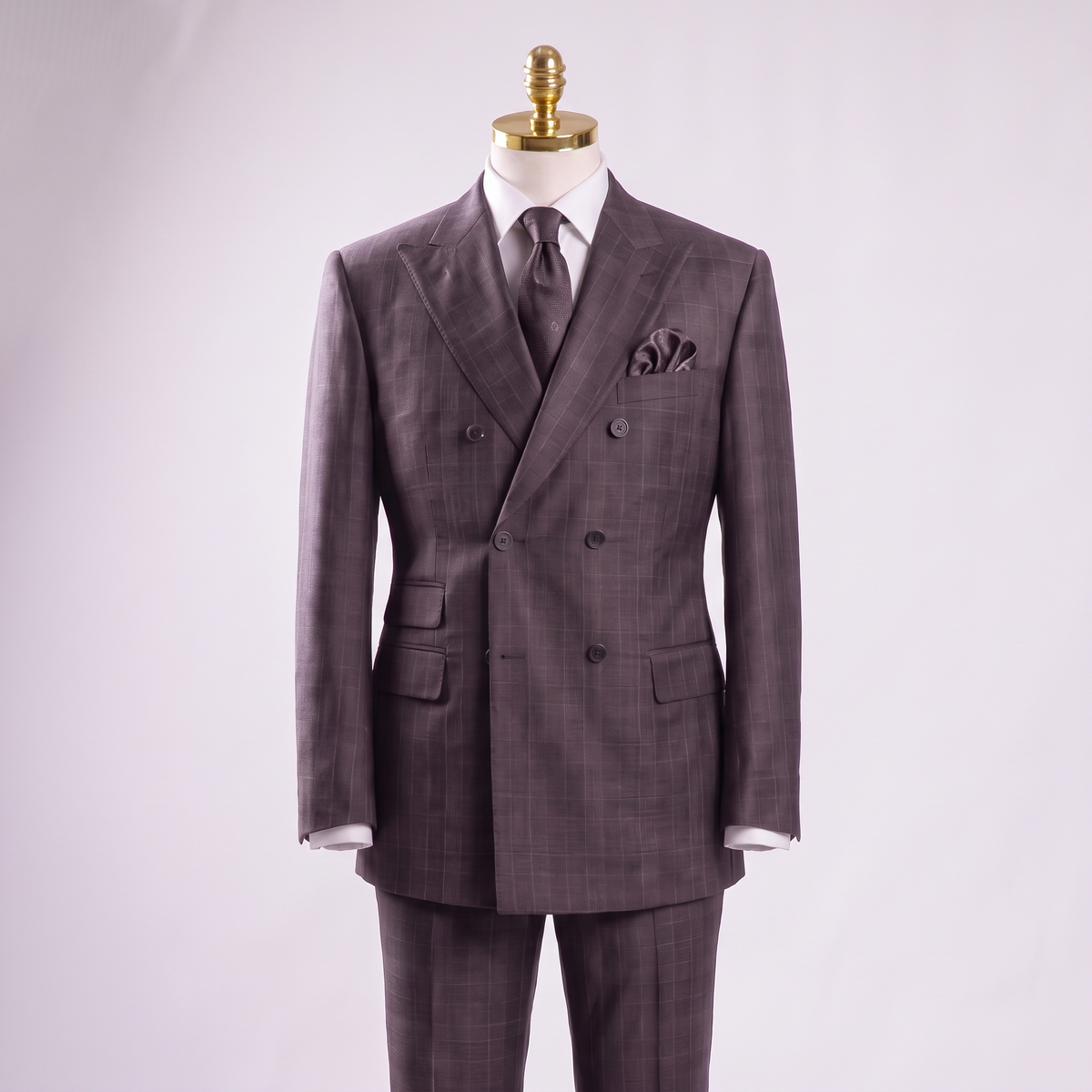 Black glen plaid double-breasted suit on gold-top mannequin with matching trousers partially visible
